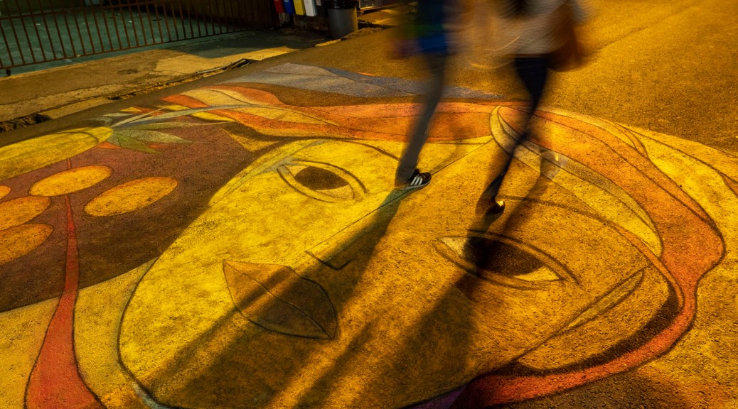 People walking on top of street art. Photo by Eduardo Libby